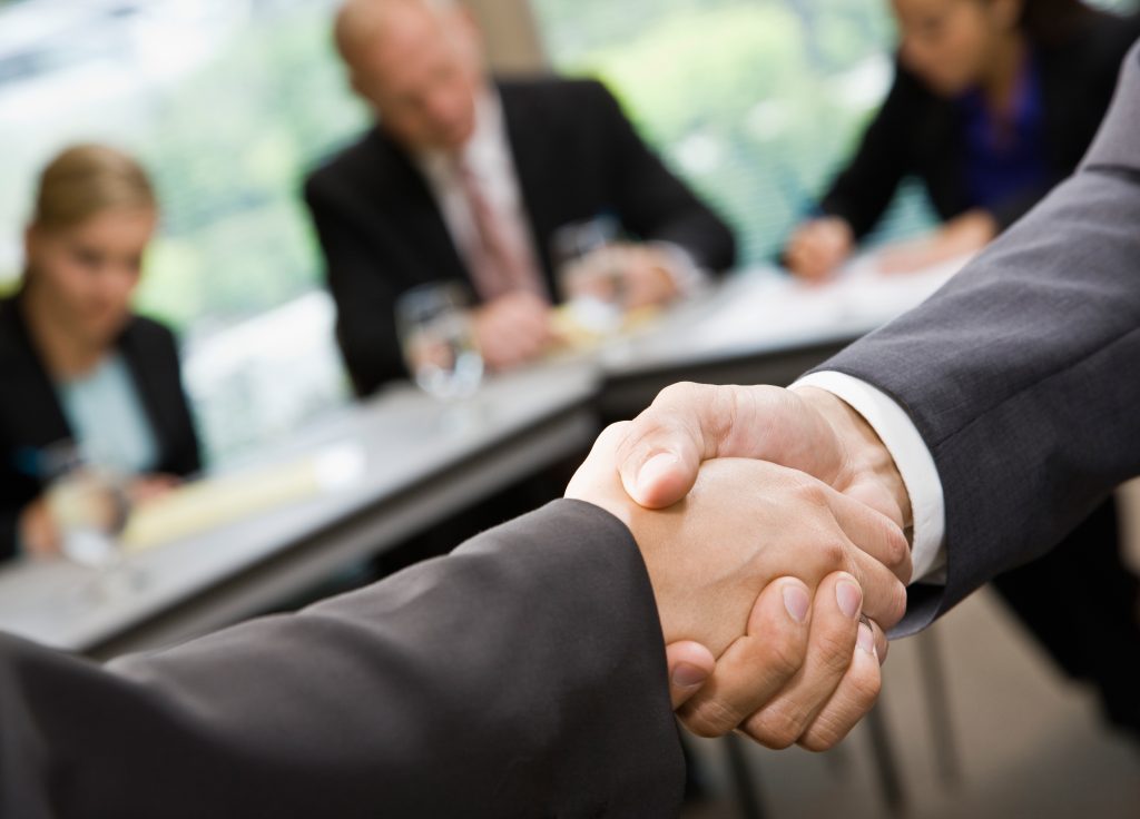 business meeting with two individuals shaking hands